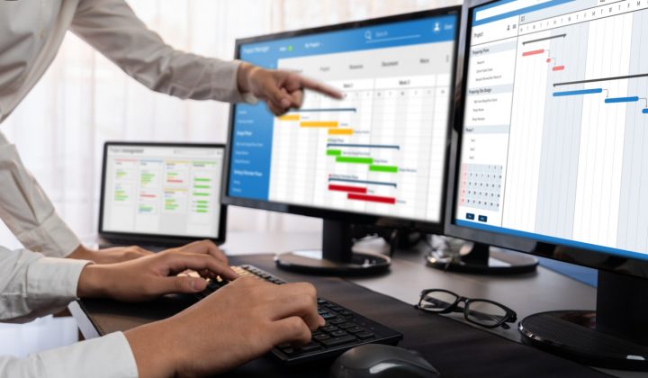 Project management team coordinating and update project planned schedule on computer using Gantt chart software in office. Business people planning time and deadline for company task. Trailblazing