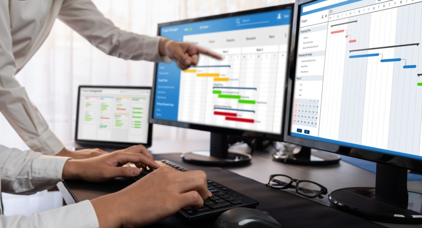 Project management team coordinating and update project planned schedule on computer using Gantt chart software in office. Business people planning time and deadline for company task. Trailblazing