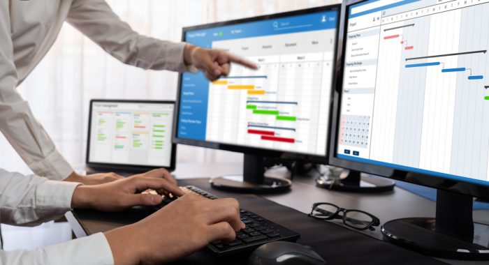 Project management team coordinating and update project planned schedule on computer using Gantt chart software in office. Business people planning time and deadline for company task. Trailblazing
