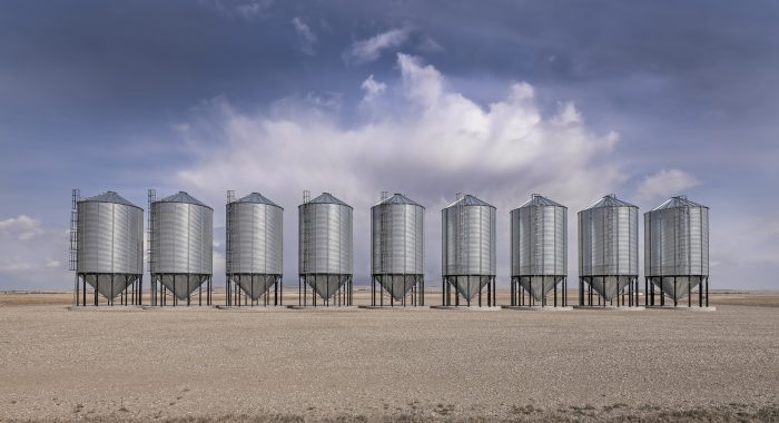 A row of steel grain storage bins near the village of Herronton, Alberta, Canada