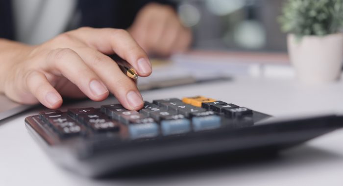 Accountant calculates expenses pressing calculator on office desk, finance budgeting tax audit bookkeeping accuracy business numbers management concept minimal workspace
