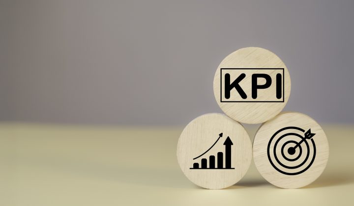 KPI Measurement for Business Success key Indicators to Track Goals and Performance on wood label. Marketing strategies, realistic objectives, and controlled planning for optimal results.