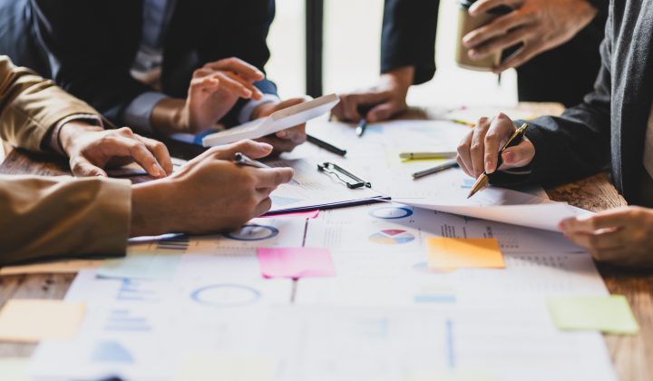 Brainstorm business meeting to discuss analysis of financial figures, graphs and growth charts of business investments to plan new business projects.