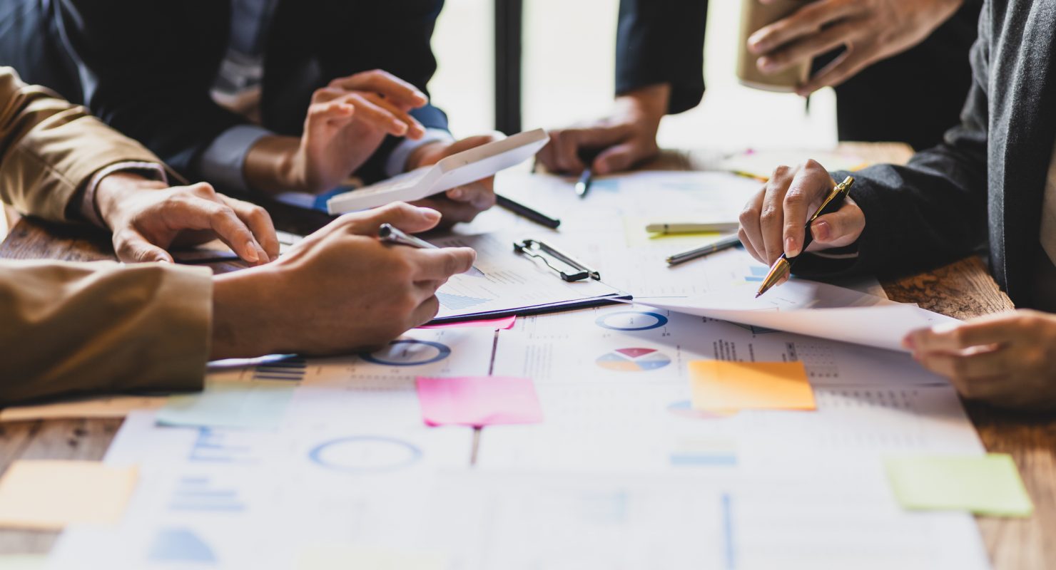 Brainstorm business meeting to discuss analysis of financial figures, graphs and growth charts of business investments to plan new business projects.