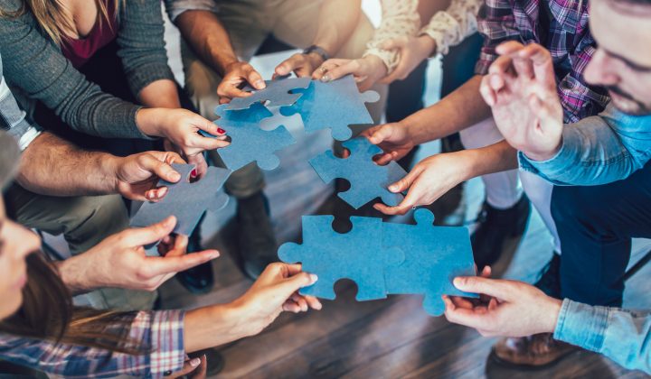 people holding puzzle pieces