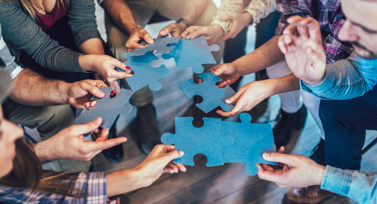 people holding puzzle pieces
